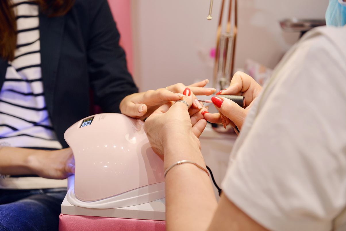 A Manicurist Putting Nail Polish on her Client's Fingernails